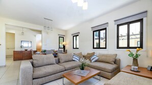 Ein modernes Wohnzimmer mit einer Sofagarnitur, einem Couchtisch und einem Essbereich.