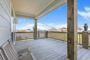 A wooden deck with a railing, a bench, and a statue of an owl.