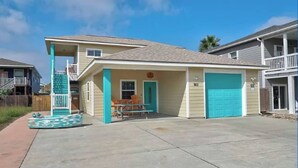 Une maison à deux étages avec un porche à l’avant, une piscine et un garage.