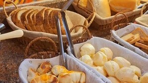 Un bufé con diversos productos de panadería, incluyendo pan, bollos y pasteles.