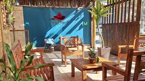 Un área de estar al aire libre con mobiliario de madera y plantas en macetas.