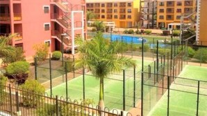 A multi-story hotel with balconies, a swimming pool, and a tennis court. - Luxury apartment in Residencial El Mocan (Palm-Mar)