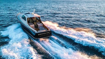 A luxury yacht named 'BRENTON ONE' cruising on the water.