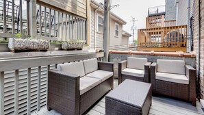 An outdoor patio with wicker furniture and planters. - 3 Flat Building Downtown - With Private Patios (Chicago)