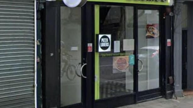 A storefront with a green and black facade, a glass door, and a sign that reads "basilico."