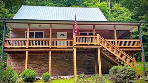 A two-story building with a wooden balcony and a staircase leading to the upper floor.