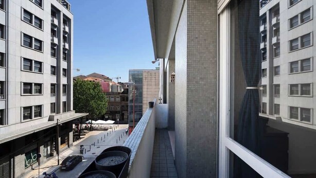 Ein modernes Stadtgebäude mit einem Balkon mit Blick auf eine Straße.