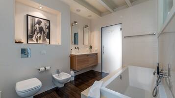 Een bad/douchecombinatie, een haardroger, een bidet, handdoeken