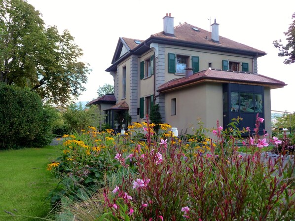 A two-story house with a garden in front.