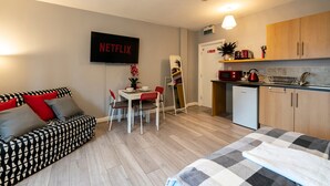 A modern apartment with a living area, kitchenette, and a dining space. - Grey Stone Studio Apartments (Halifax)
