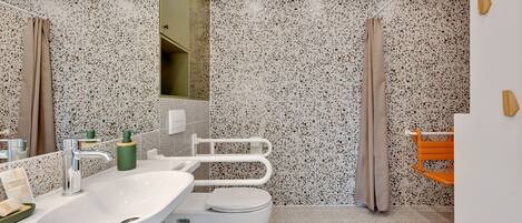 Une salle de bain moderne avec un grand lavabo, des toilettes et une douche.