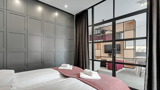 Une chambre d’hôtel moderne dotée d’un grand lit, d’une télévision et d’un balcon avec un espace repas.