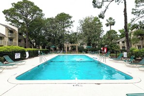 Ein Schwimmbecken mit Liegestühlen und einem Rettungsschwimmerstand.