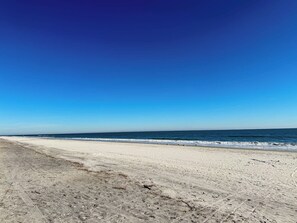 Ein Strand mit blauem Himmel und ruhigem Meer.