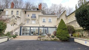 A building with a glass facade, stone walls, and a parking area. - Les Rives du Cher (Montrichard Val de Cher)