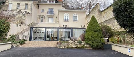 A building with a glass facade, stone walls, and a parking area.