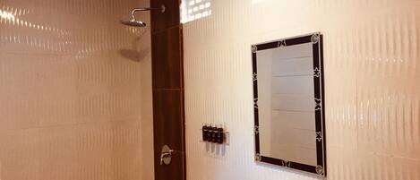 A bathroom with a shower, a sink, and a mirror.