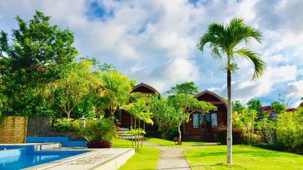 A resort with a pool, lush greenery, and bungalow-style buildings. - Druwa Bali (Kutuh)