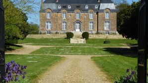 Un grand bâtiment historique à la façade symétrique, doté de nombreuses fenêtres et d’une entrée centrale.