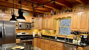 A modern kitchen with wooden cabinets, stainless steel appliances, and a black granite countertop. - LARGE elegant DESIGNER mountain cabin home on RIVER COOSAWATTEE perfect4families (ellijay)