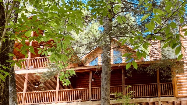 A multi-story log cabin with a balcony on each floor, surrounded by trees. - LARGE elegant DESIGNER mountain cabin home on RIVER COOSAWATTEE perfect4families (ellijay)
