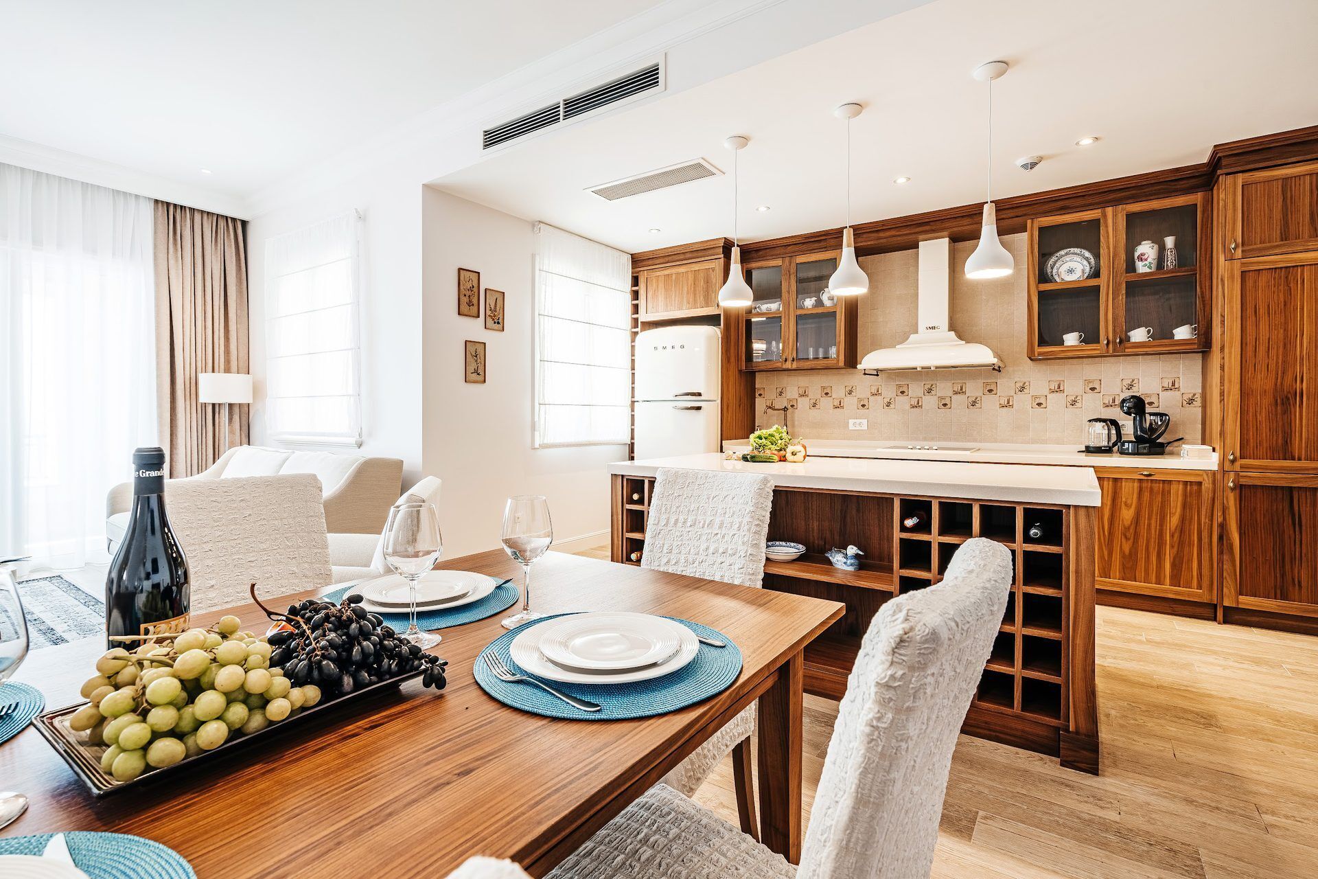 A modern kitchen with wooden cabinets, a central island, and pendant lighting.