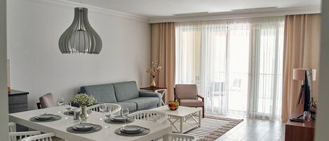 Leilighet – deluxe, 2 soverom, sjøutsikt | Oppholdsområde | En 142-centimeters TV med digitale kanaler samt bordtennis