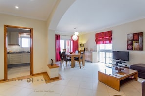 A modern apartment with a dining area, kitchen, and living room.