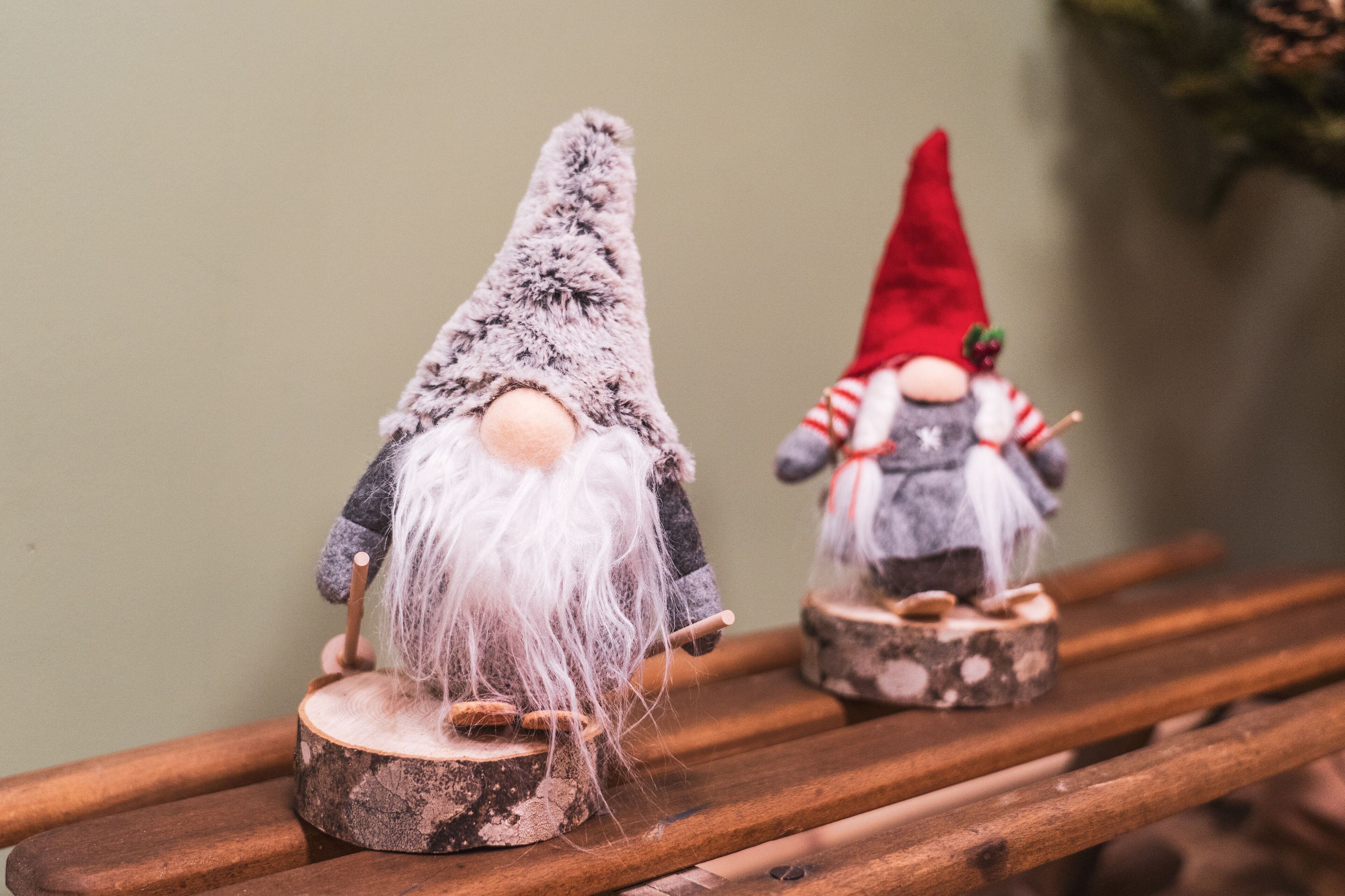 Two gnome figurines on wooden stands.