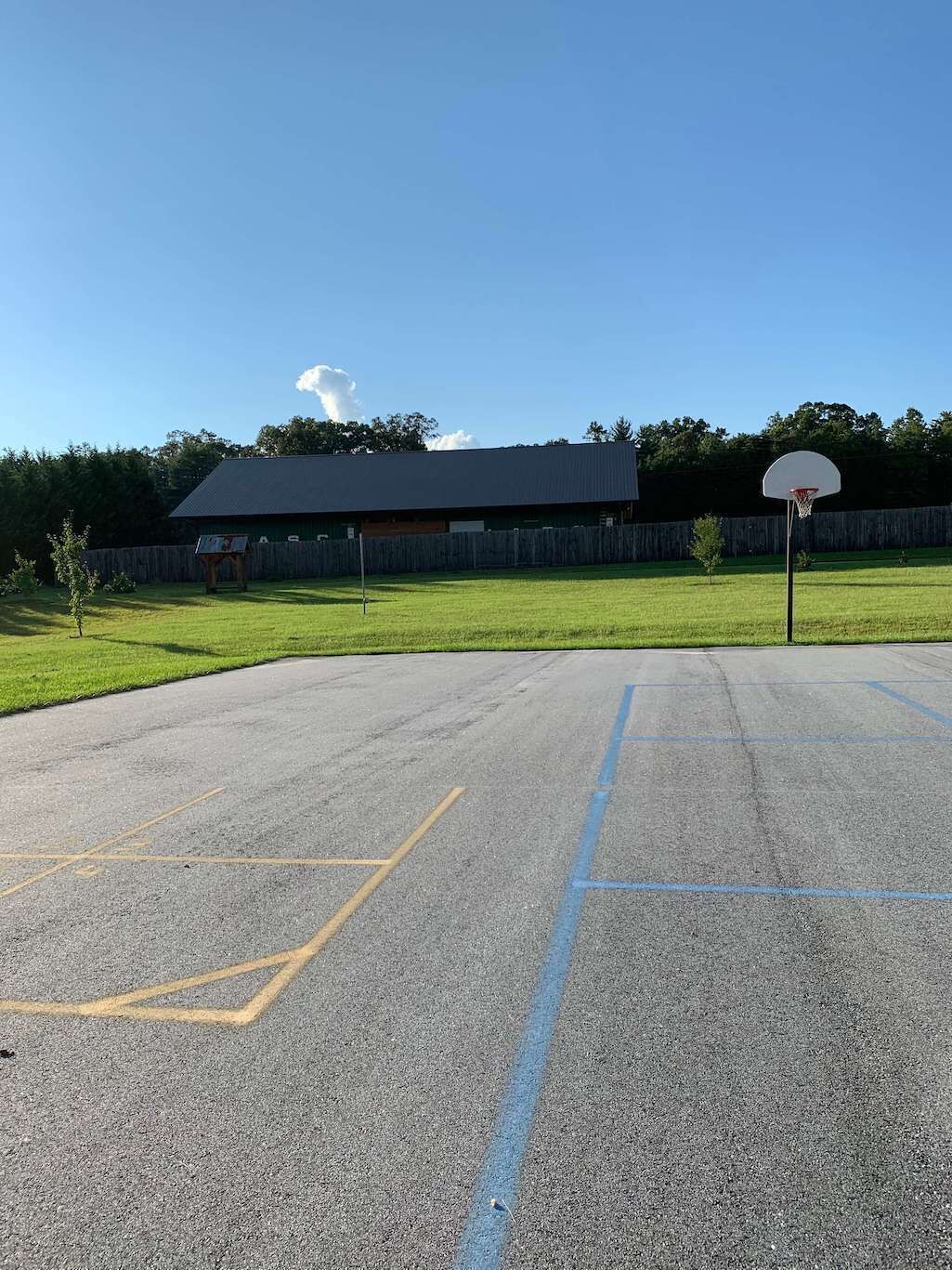 Uma quadra de basquete ao ar livre com um edifício ao fundo.