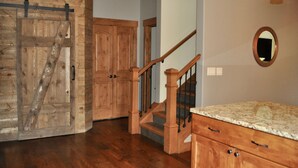 A wooden staircase with a handrail, a wooden door with a metal handle, and a marble countertop. - Gorgeous Mountain Modern Home~ Private Rooftop Hot Tub, Fireplace & 360 Views!!! (Frisco)