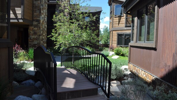 A residential building with a stone facade, a wooden deck, and a metal railing. - Gorgeous Mountain Modern Home~ Private Rooftop Hot Tub, Fireplace & 360 Views!!! (Frisco)