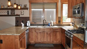 A kitchen with wooden cabinets, a stainless steel stove, and a microwave. - Gorgeous Mountain Modern Home~ Private Rooftop Hot Tub, Fireplace & 360 Views!!! (Frisco)