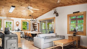 Een knus chaletinterieur met een eethoek, een bank en een open haard.