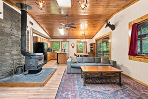 Un interior acogedor con chimenea, techo de madera y un sofá.