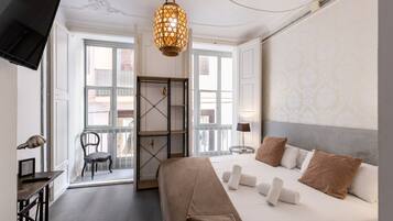 Hotelkamer met een bed, een bureau, een stoel, een kledingkast en een hanglamp.