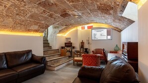 Ein gemütlicher Wohnraum mit Steindecke, einer Treppe und einem an der Wand befestigten Schild mit Empfehlungen.