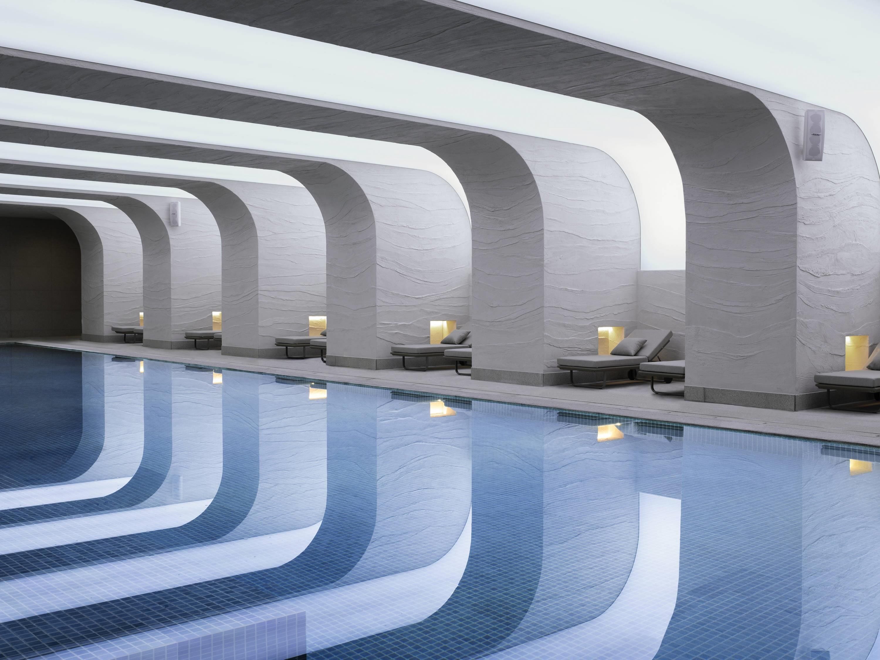 Una piscina techada, una piscina al aire libre de temporada, sombrillas