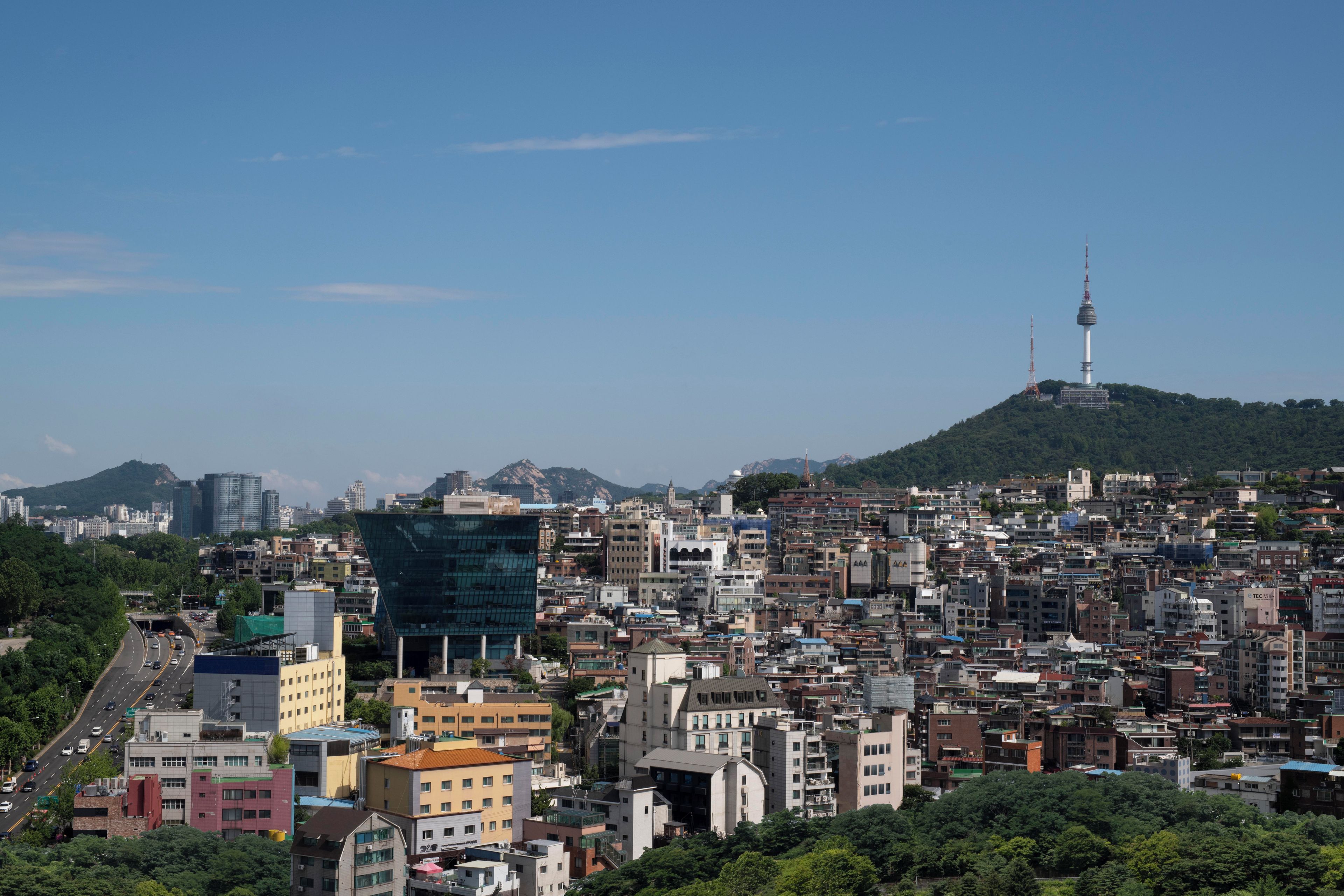 A densely packed urban area with a prominent tower on a hill in the background.