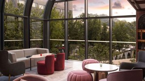 A modern lounge with a curved glass ceiling, offering expansive views of the surrounding greenery and cityscape. - Mondrian Seoul Itaewon (Seoul)