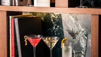 A bookshelf with books and three martini glasses.