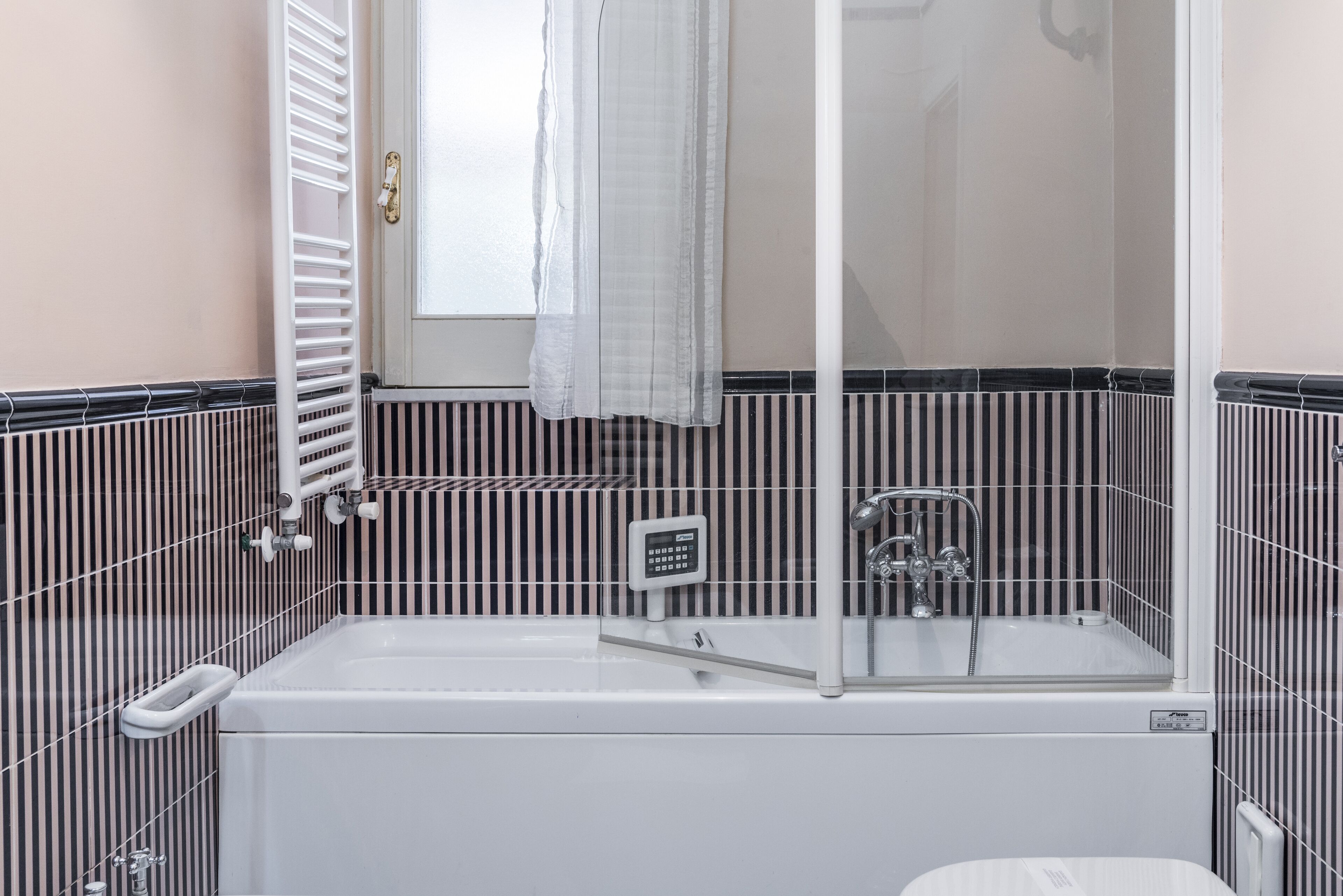 A modern bathroom with a bathtub, a shower enclosure, and a toilet.