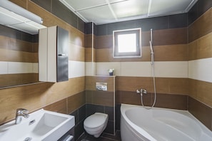 A modern bathroom with a bathtub, toilet, and sink.