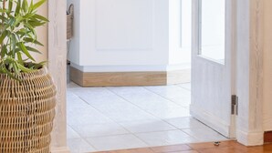 Un comptoir d’accueil avec un mur vert et l’inscription « Villa Bina » au-dessus.