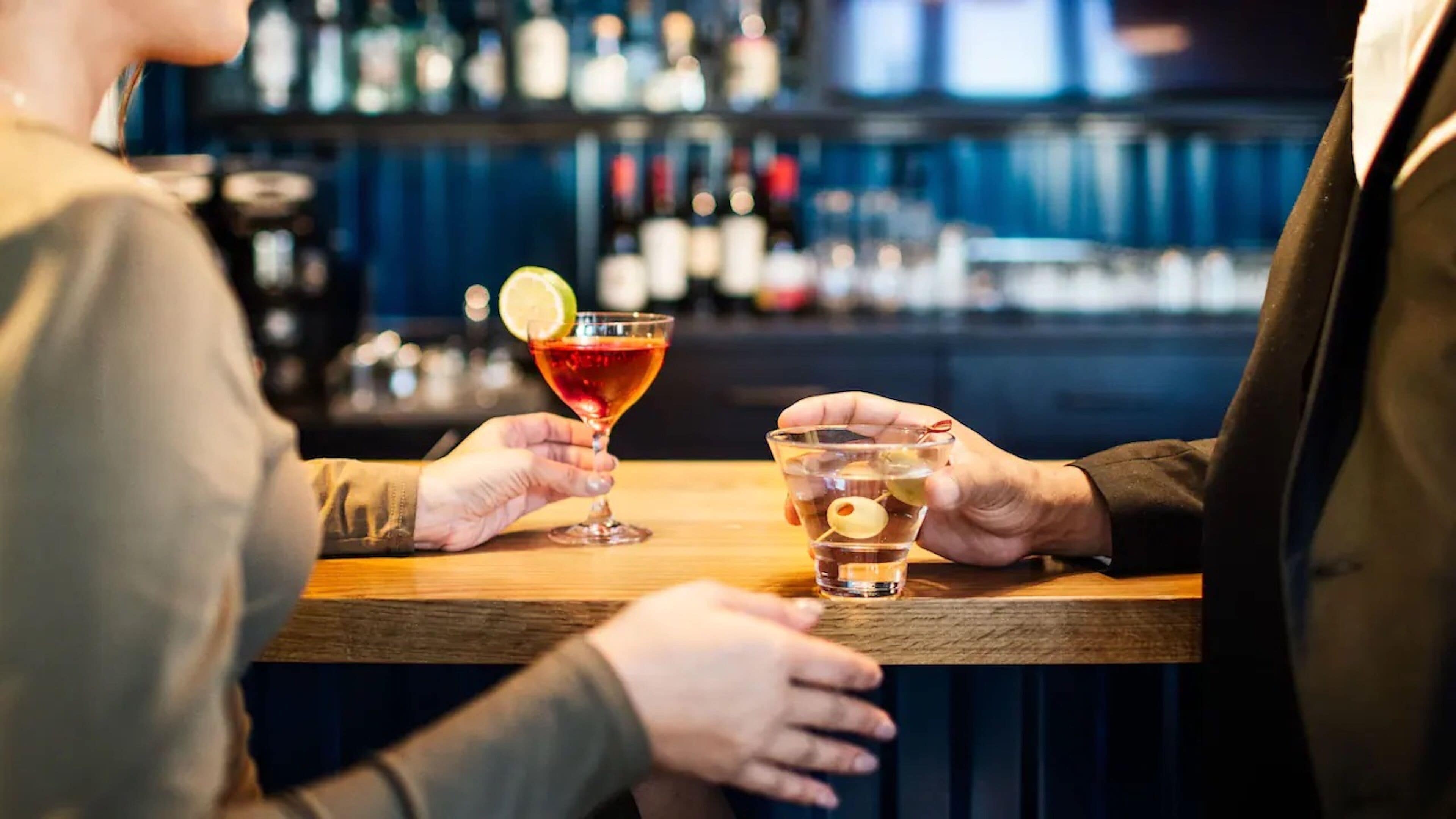 Dos personas en un bar, disfrutando de bebidas.