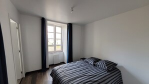 Une chambre à coucher avec un lit, une fenêtre et un radiateur.