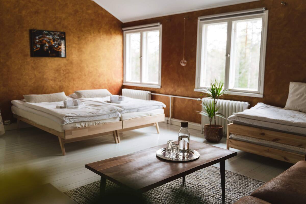 A modern bedroom with a wooden bed, a wooden coffee table, and a potted plant.