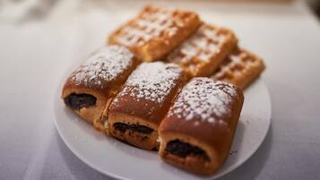 A plate of freshly baked pastries dusted with powdered sugar.