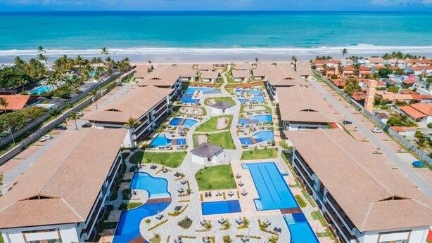 Een resort met meerdere zwembaden, een centrale binnenplaats en uitzicht op het strand.