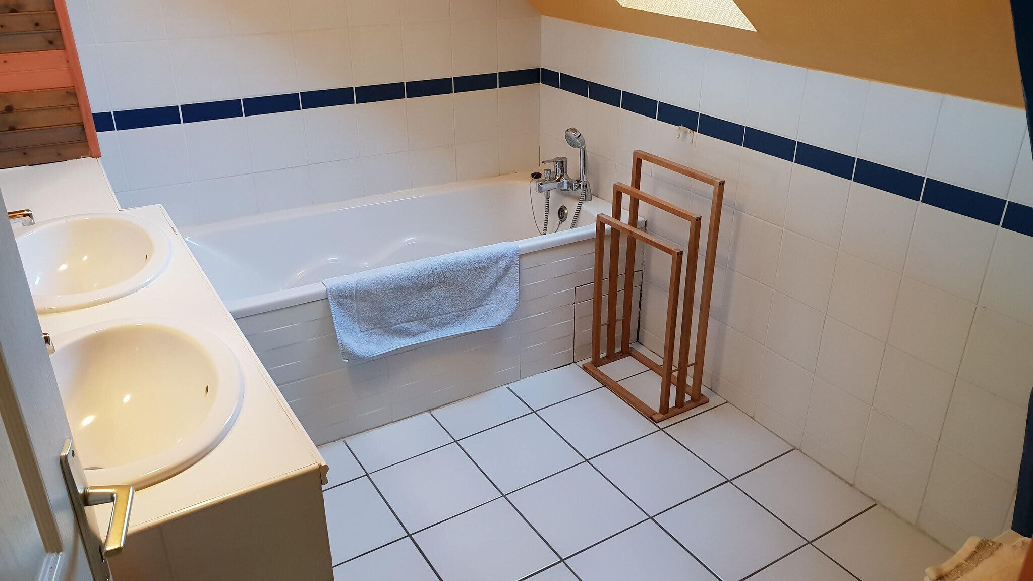 Un baño con bañera, dos lavamanos y estructura de madera.